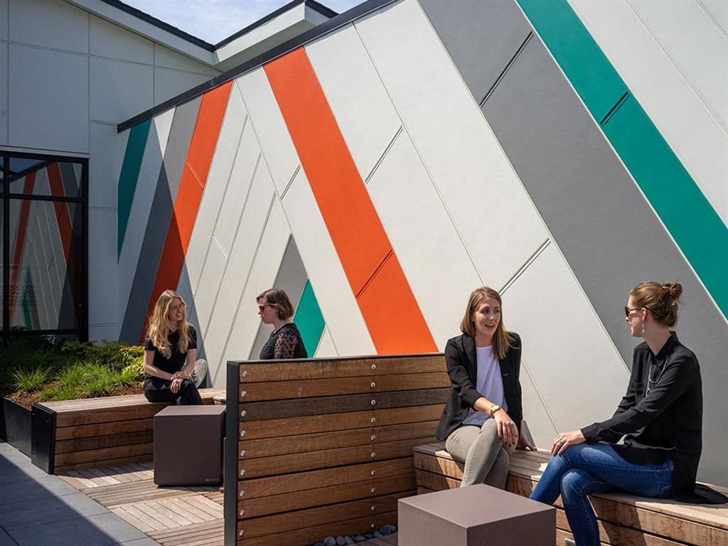 people sitting on benches outside of a building
