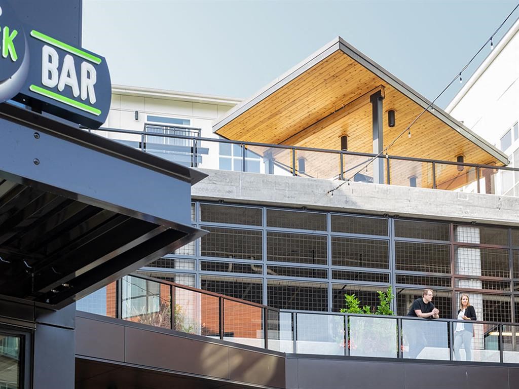 people on the balcony of a bar on the side of a building