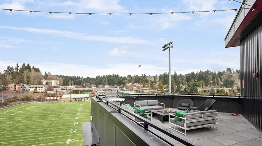 a roof terrace with a soccer field and chairs on it