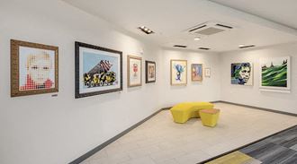a room with pictures on the wall and a yellow bench