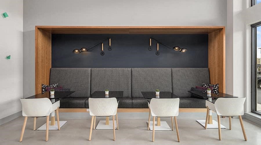 a restaurant with white chairs and tables and a grey couch