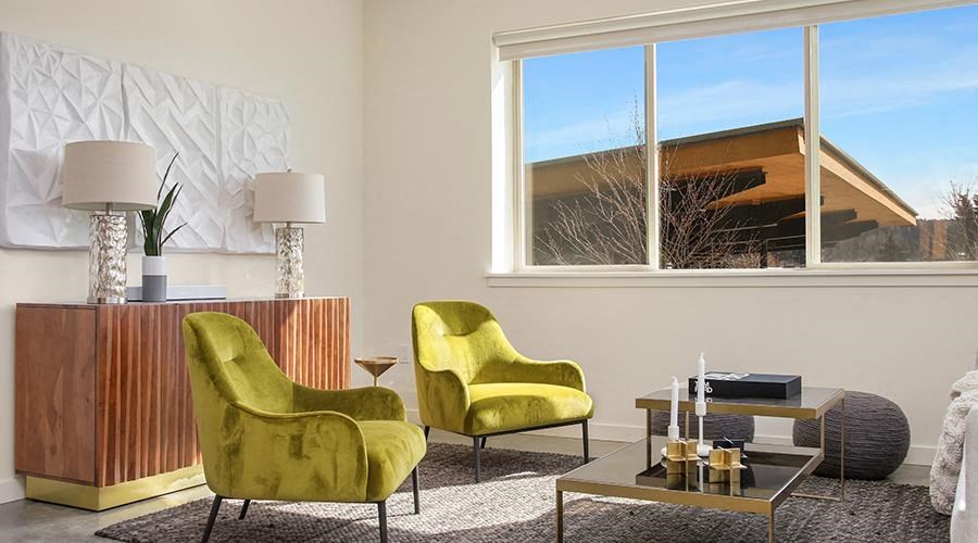 a living room with two yellow chairs and a table