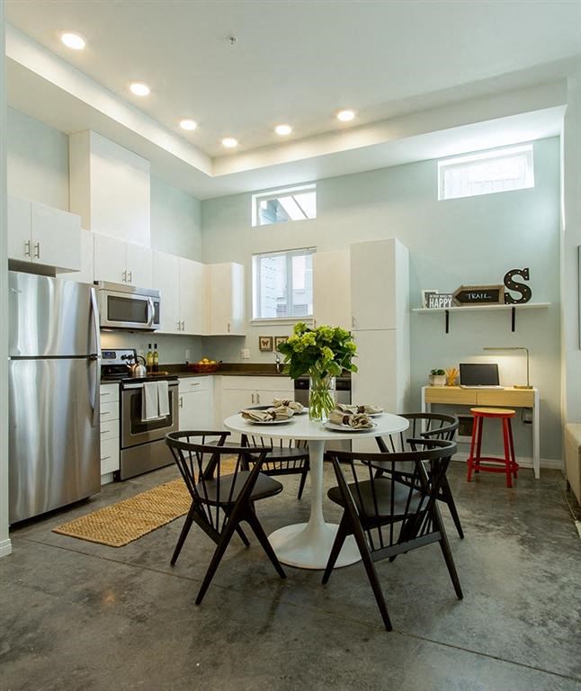 a kitchen with a table and chairs and a refrigerator