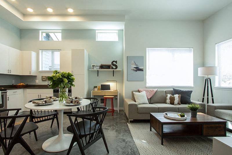 a living room and kitchen with a table and chairs
