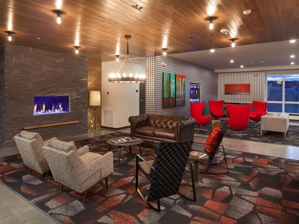 a living room with chairs and a fireplace