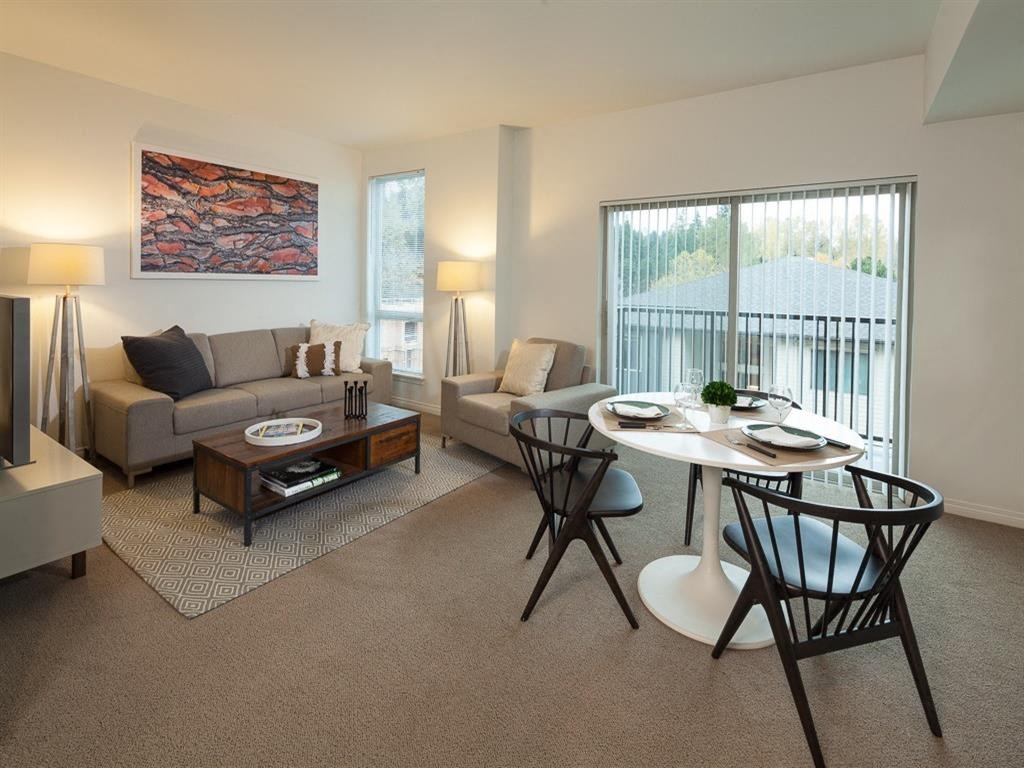 a living room and dining room with a table and chairs