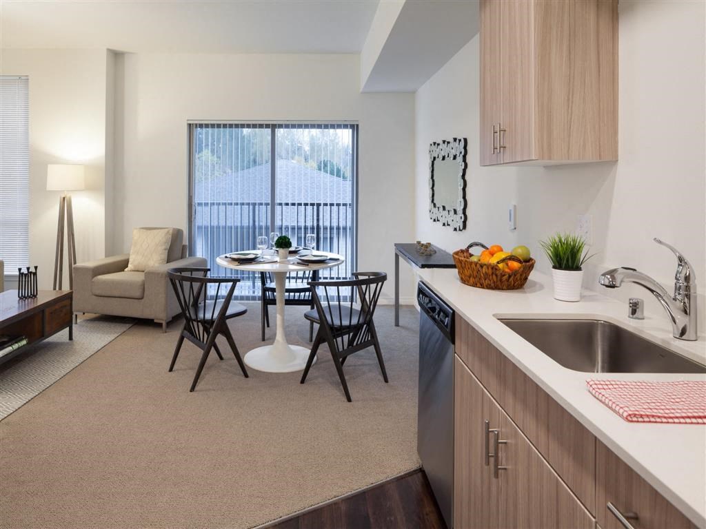 a kitchen with a sink and a table with chairs