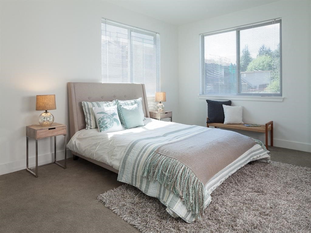 a bedroom with a bed and two windows