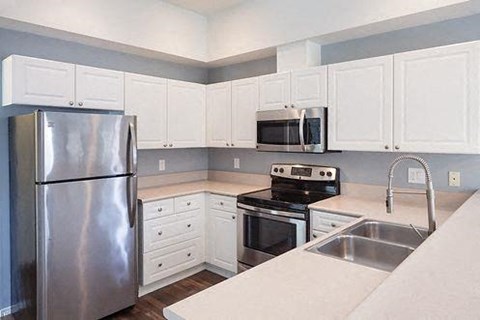 a kitchen with stainless steel appliances and white cabinets