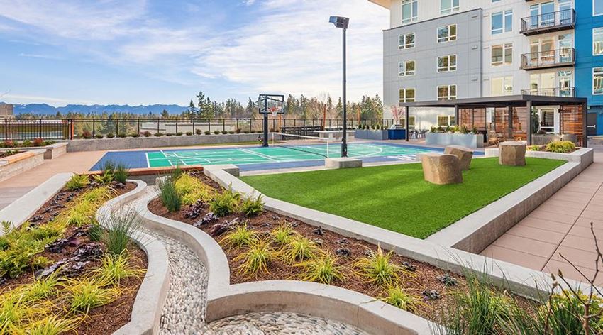 an apartment building with a basketball court and a tennis court