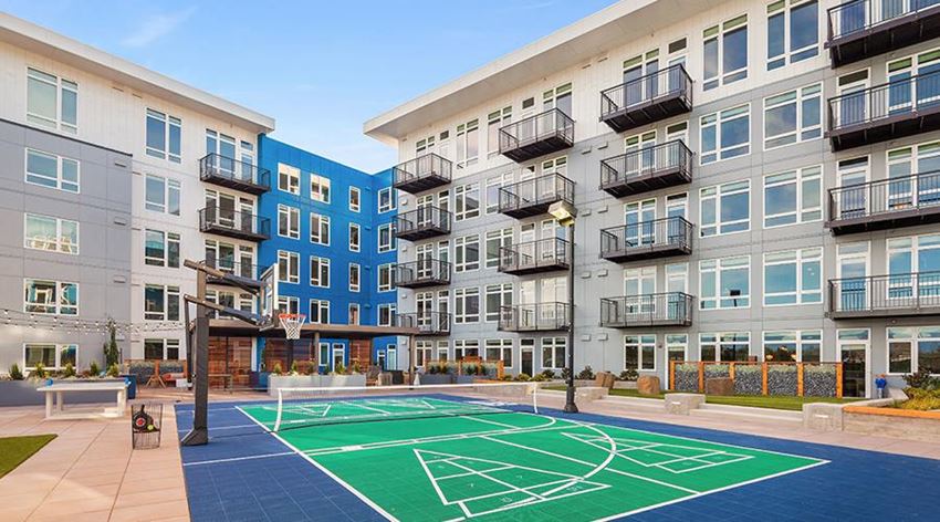 an outdoor basketball court in front of an apartment building