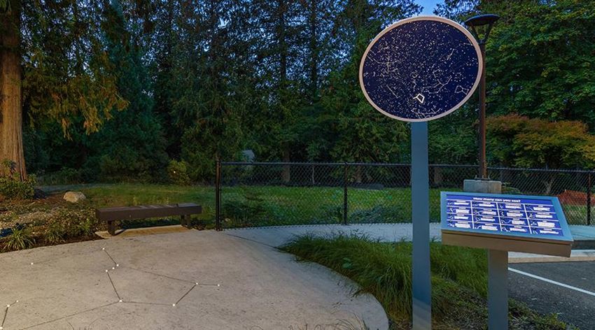 a park with a sign and a bench