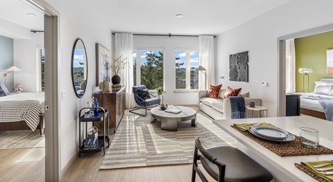 A modern living room with a dining table set for two.
