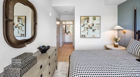 A bedroom with a large bed and a mirror on the wall.