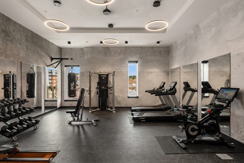 a large fitness room with cardio equipment and weights