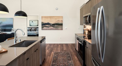 A modern kitchen with a stainless steel refrigerator and wooden cabinets.