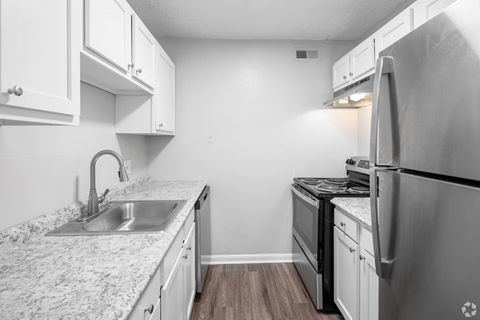 A kitchen with a granite countertop and stainless steel appliances.