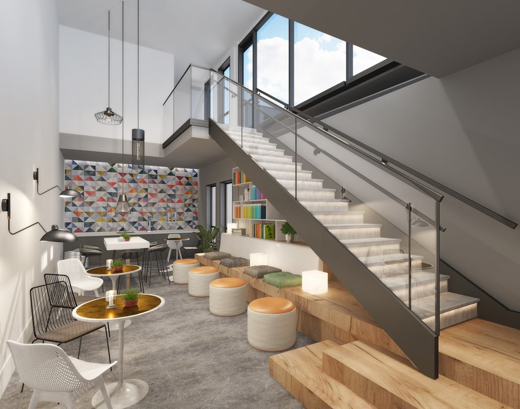 a living room with a staircase and tables and chairs