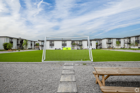 A soccer goal stands in the middle of a grassy field.