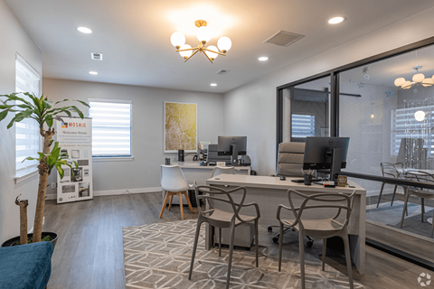 A modern office space with a desk, chairs, and a computer.