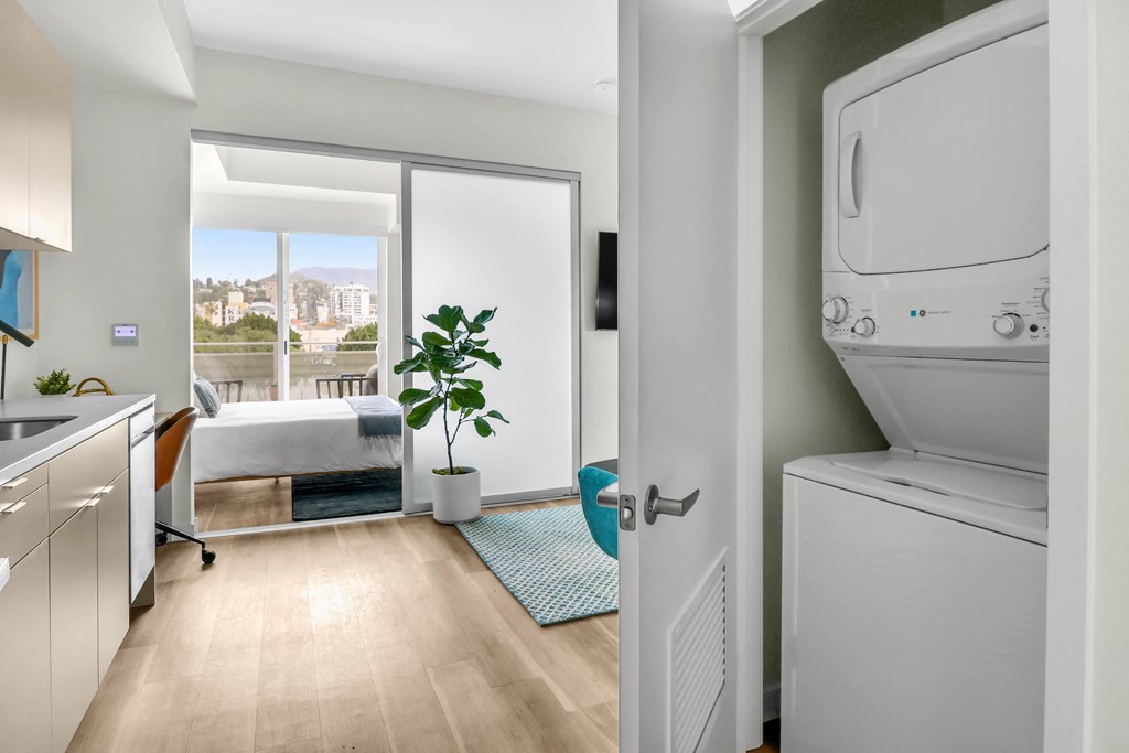 a bedroom with a large window and a washer and dryer