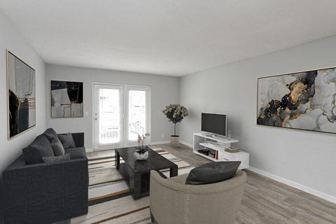 A living room with a grey couch, a black chair, a coffee table, a television, and two paintings on the wall.