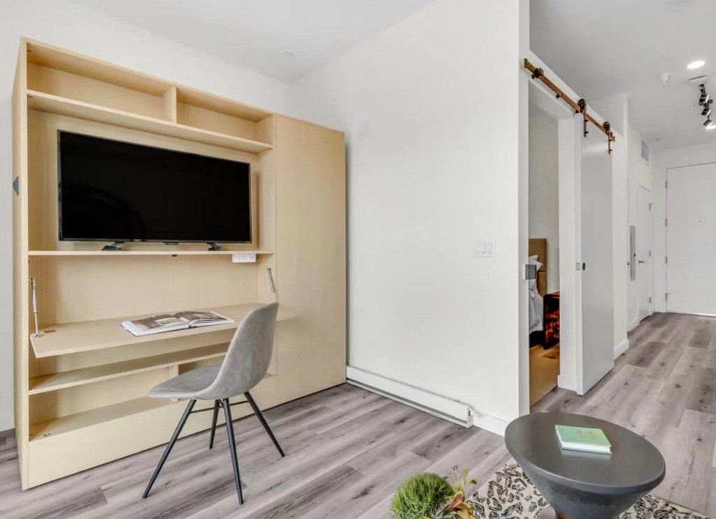 a bedroom with a medium sized bed and a chair in front of a tv