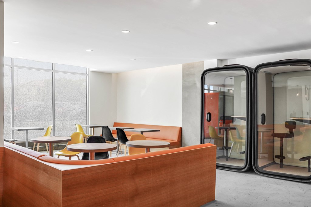a seating area with tables and chairs in front of a glass door