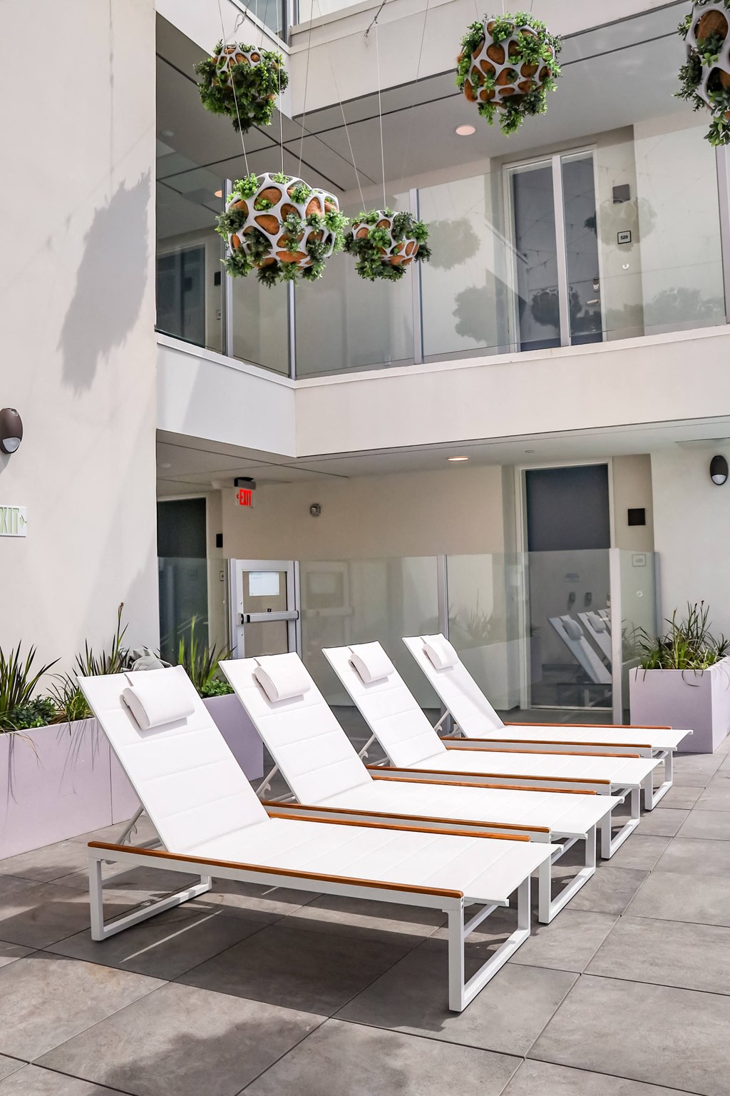 a row of white chaise lounges in front of a white building