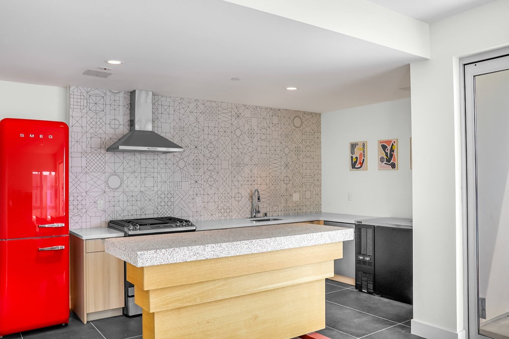 a kitchen with a large island and a red fridge