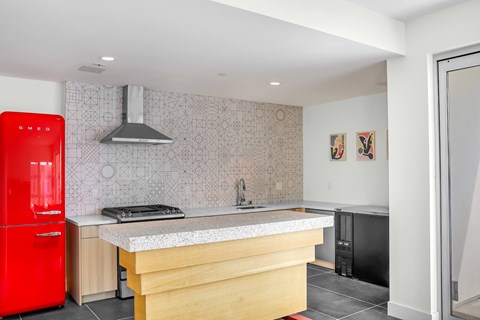 a kitchen with a wooden island and a red refrigerator
