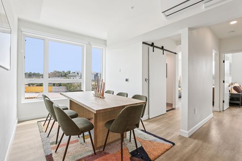 A dining room with a table and chairs.