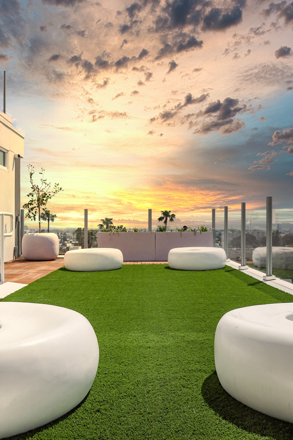 a rendering of a rooftop garden with grass and a sunset in the background
