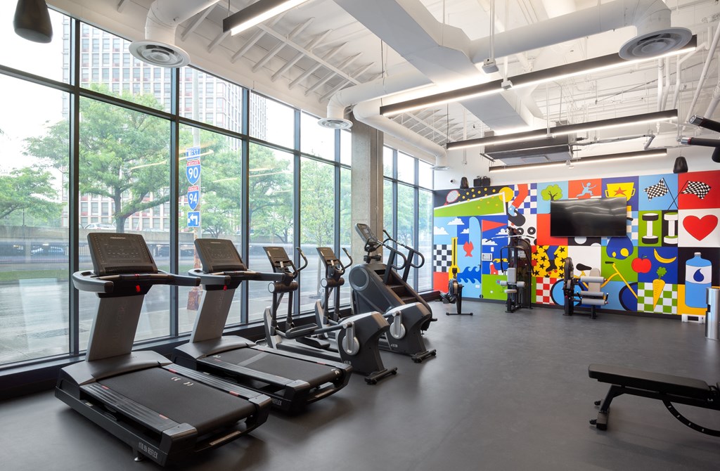 a gym with cardio machines and a wall of windows a gym with cardio machines and a wall of windows at Inspire West Town, CHICAGO