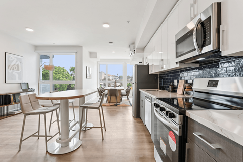 A modern kitchen with a dining table and chairs.