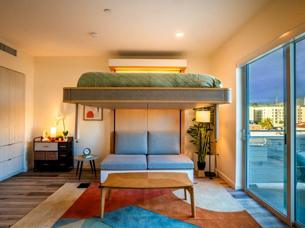 a loft bed in a room with a couch and a table