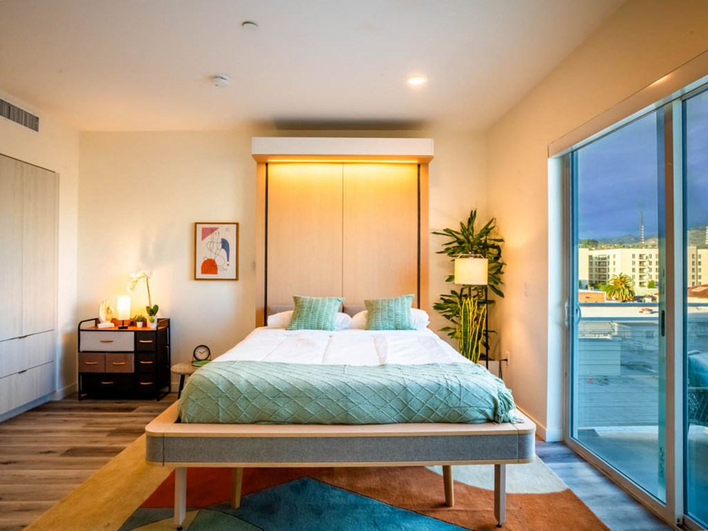 a bedroom with a bed and a sliding glass door