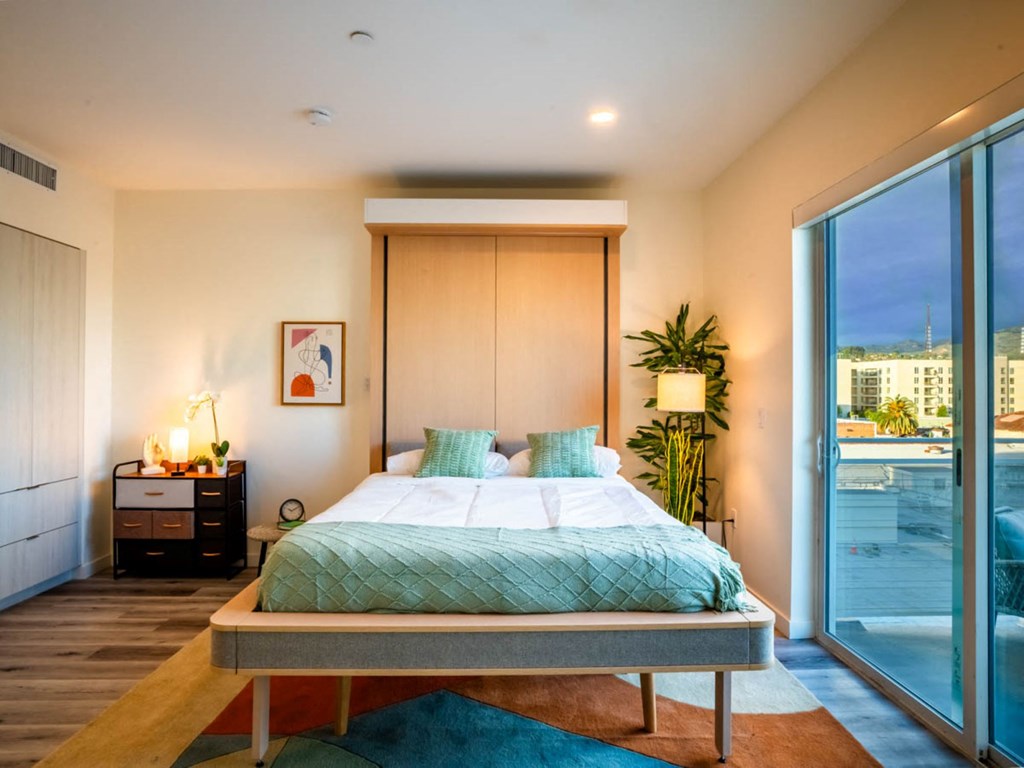 a bedroom with a bed and a large window