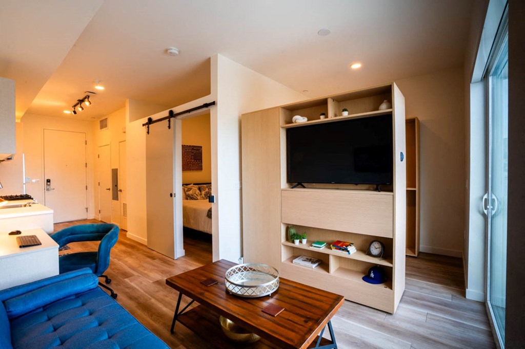 a living room with a blue couch and a television