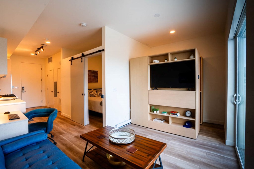 a living room with a blue couch and a television