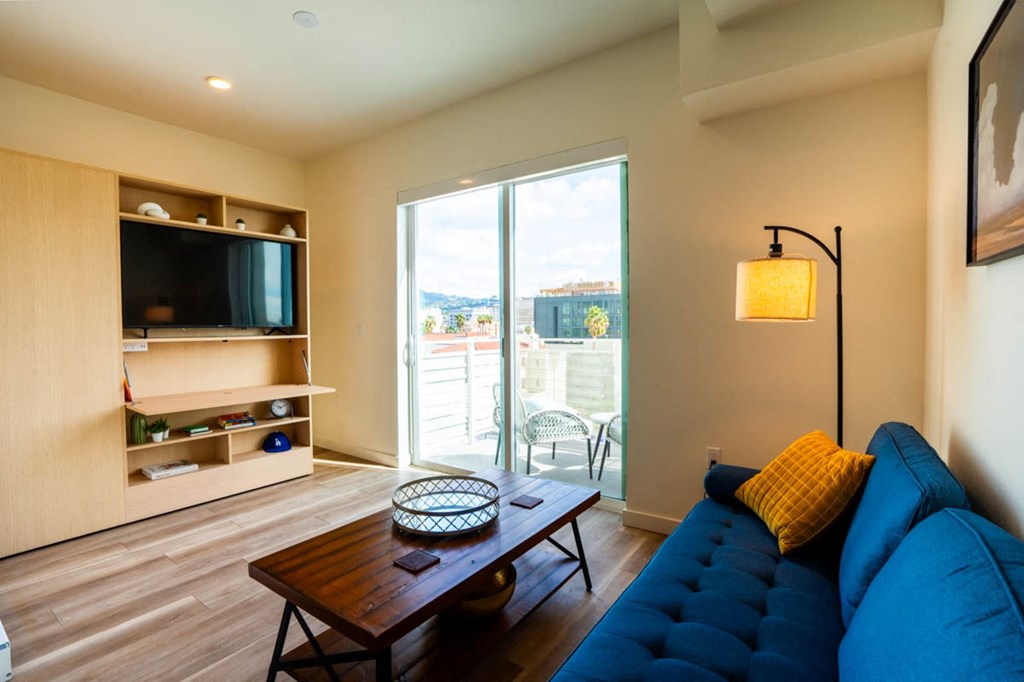a living room with a blue couch and a television