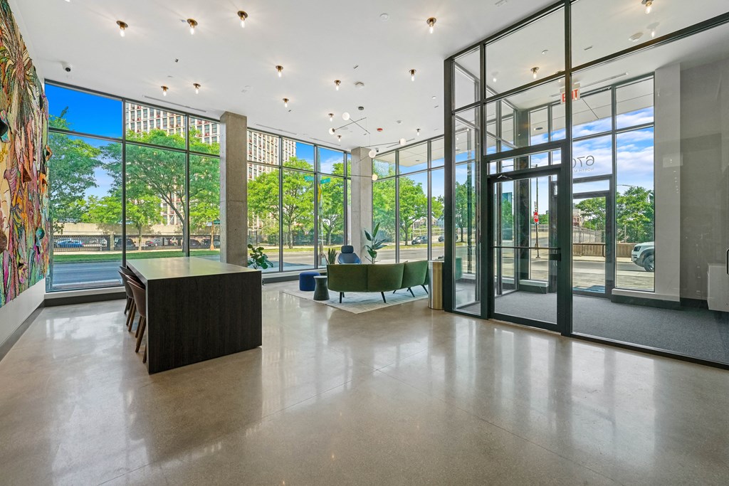 the lobby of a building with glass doors and a table and chairs  at Inspire West Town, Illinois