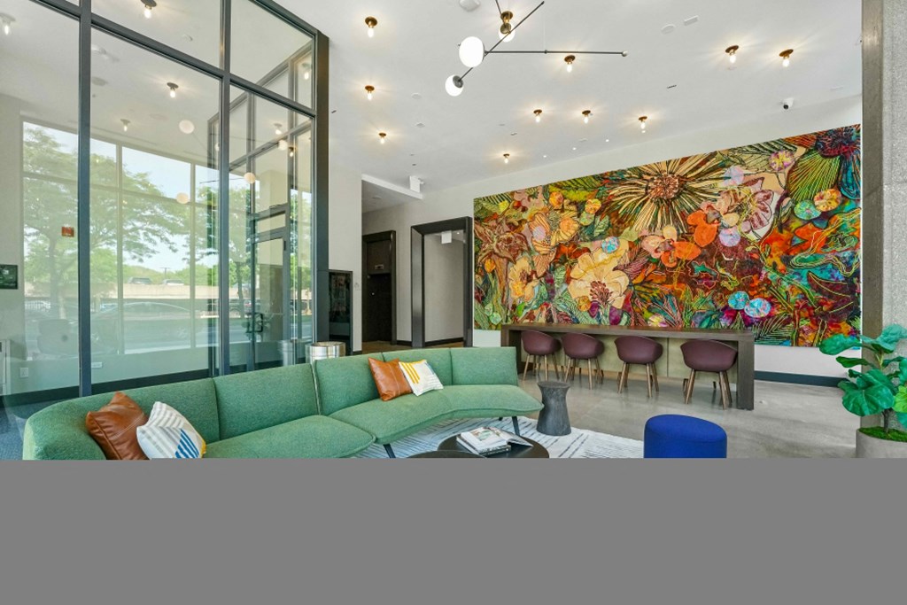 a living room with a green couch and a colorful mural on the wall  at Inspire West Town, CHICAGO, 60642