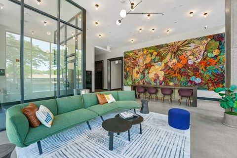 a living room with a green couch and a colorful mural on the wall  at Inspire West Town, CHICAGO, 60642