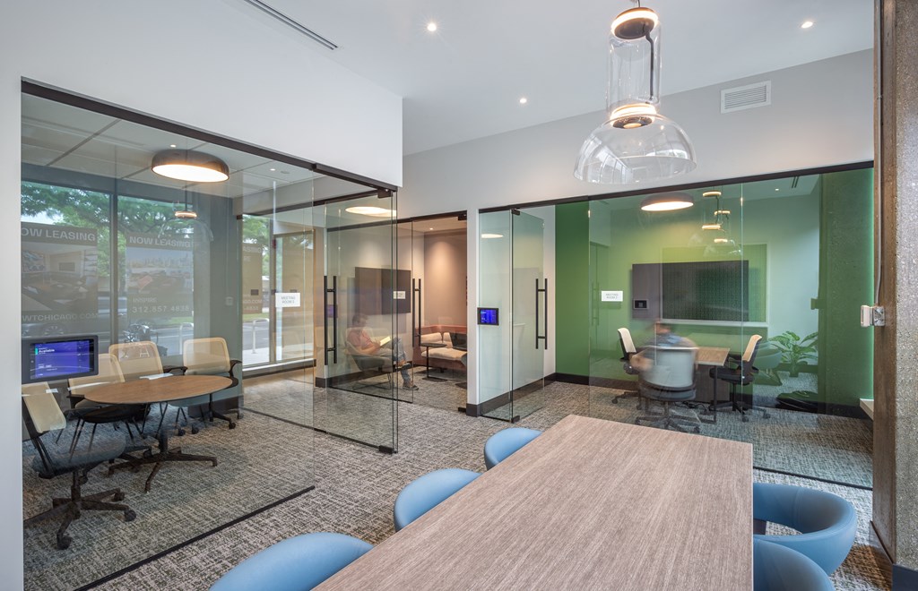a conference room with a table and chairs and a television  at Inspire West Town, CHICAGO, IL, 60642