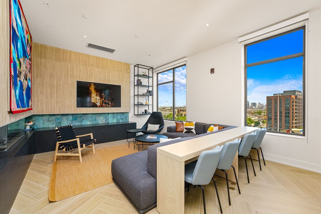 a living room with a long table and chairs and a fireplace  at Inspire West Town, CHICAGO, 60642