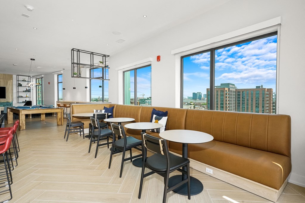 a communal seating area with tables and chairs in a restaurant with a city view  at Inspire West Town, CHICAGO, Illinois