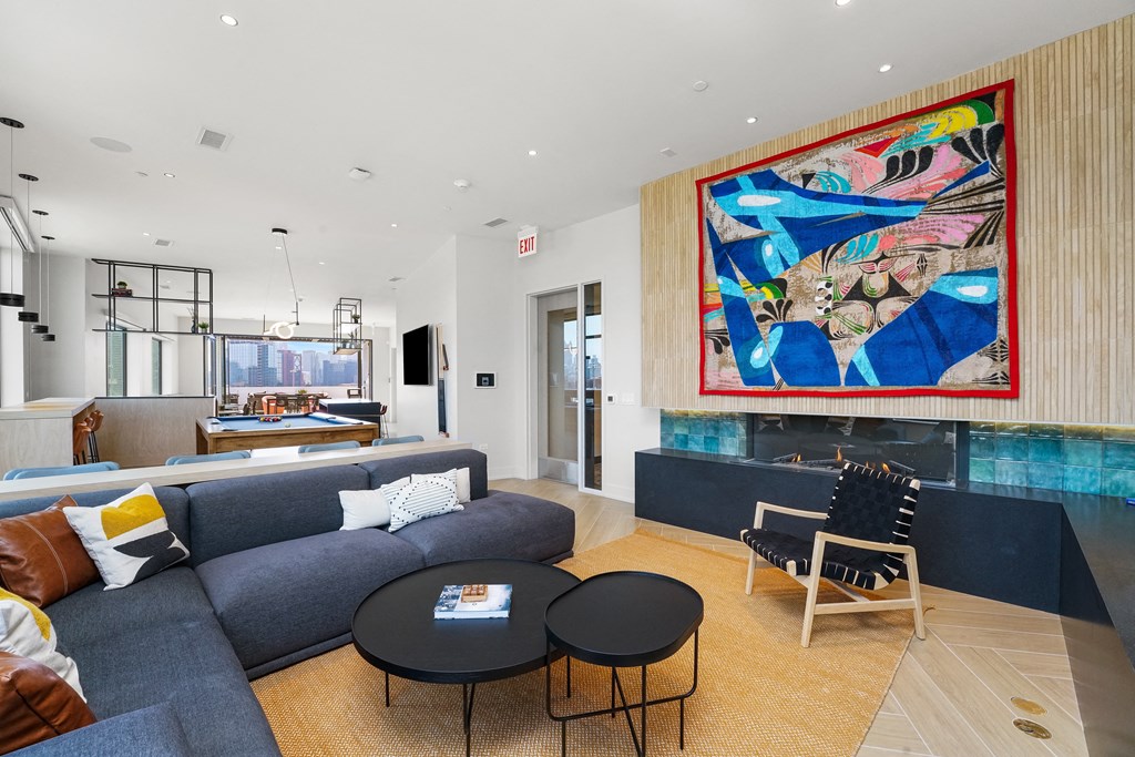 a living room with a blue couch and a colorful painting on the wall  at Inspire West Town, Illinois, 60642