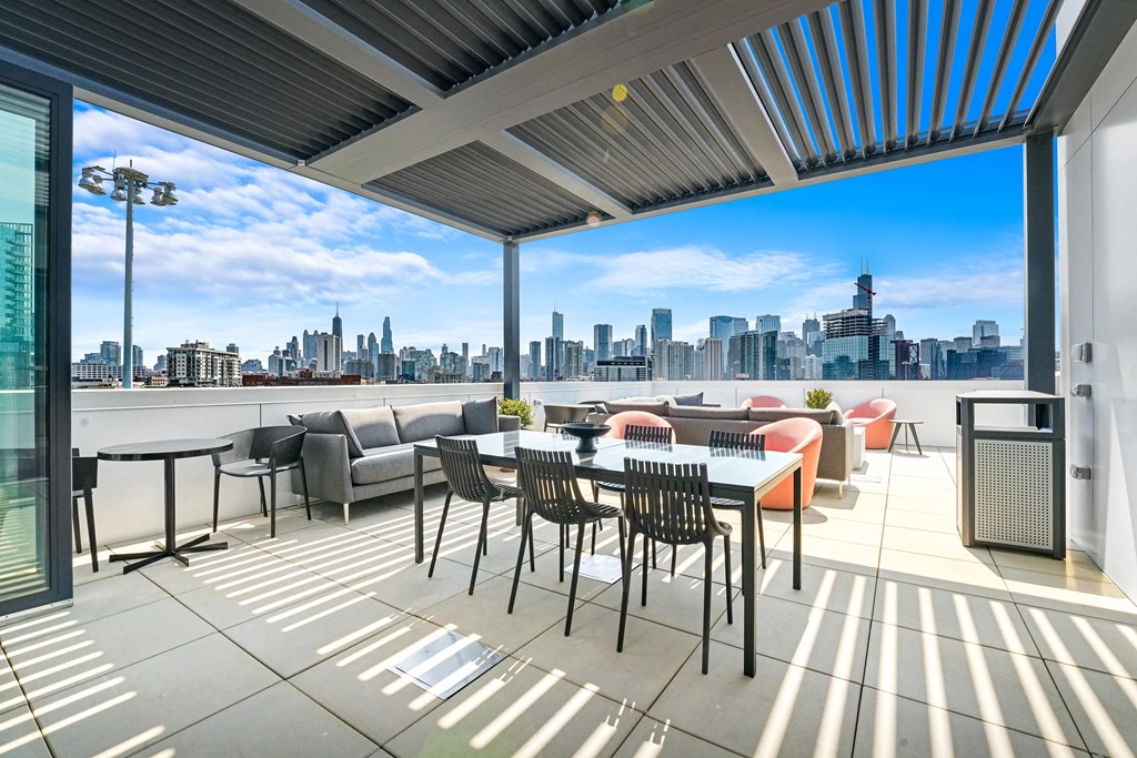 a terrace with a table and chairs and a view of the city  at Inspire West Town, CHICAGO, IL, 60642