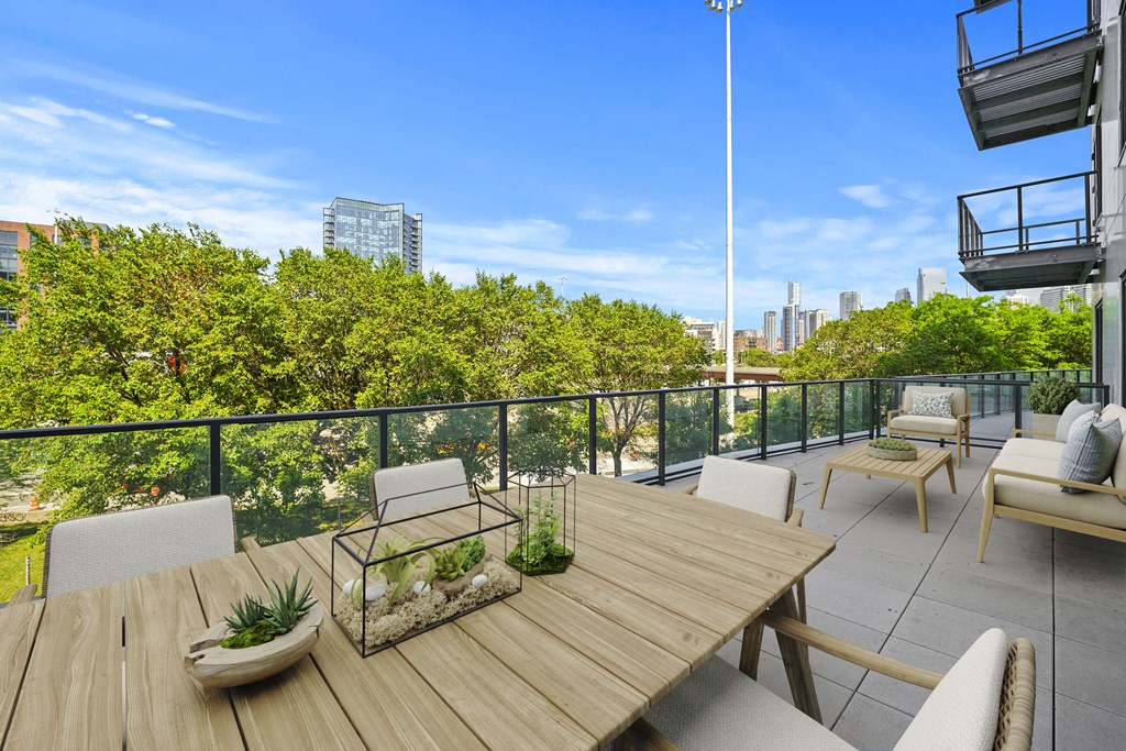 a patio with a wooden table and chairs on a balcony at Inspire West Town, CHICAGO